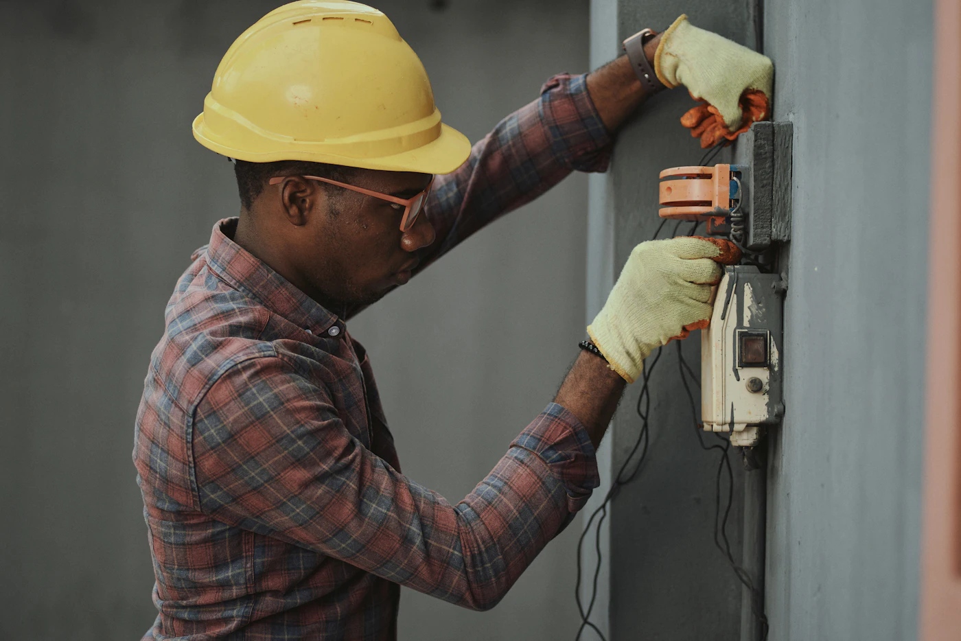 Technician in a hard hat working on an electrical meter