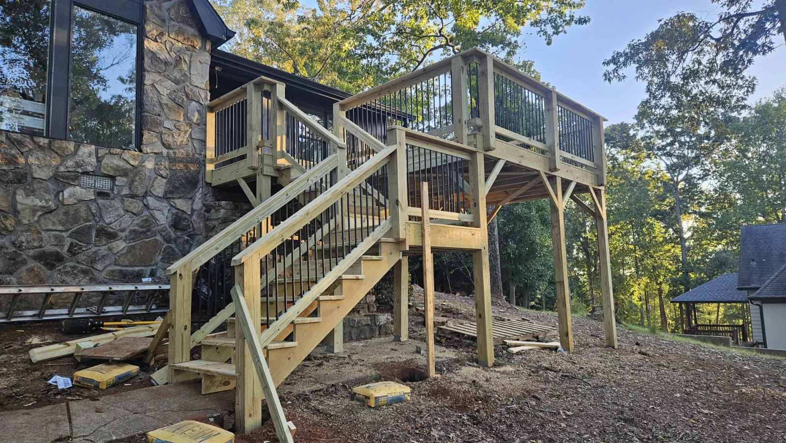 New elevated wood deck and staircase with black metal balusters