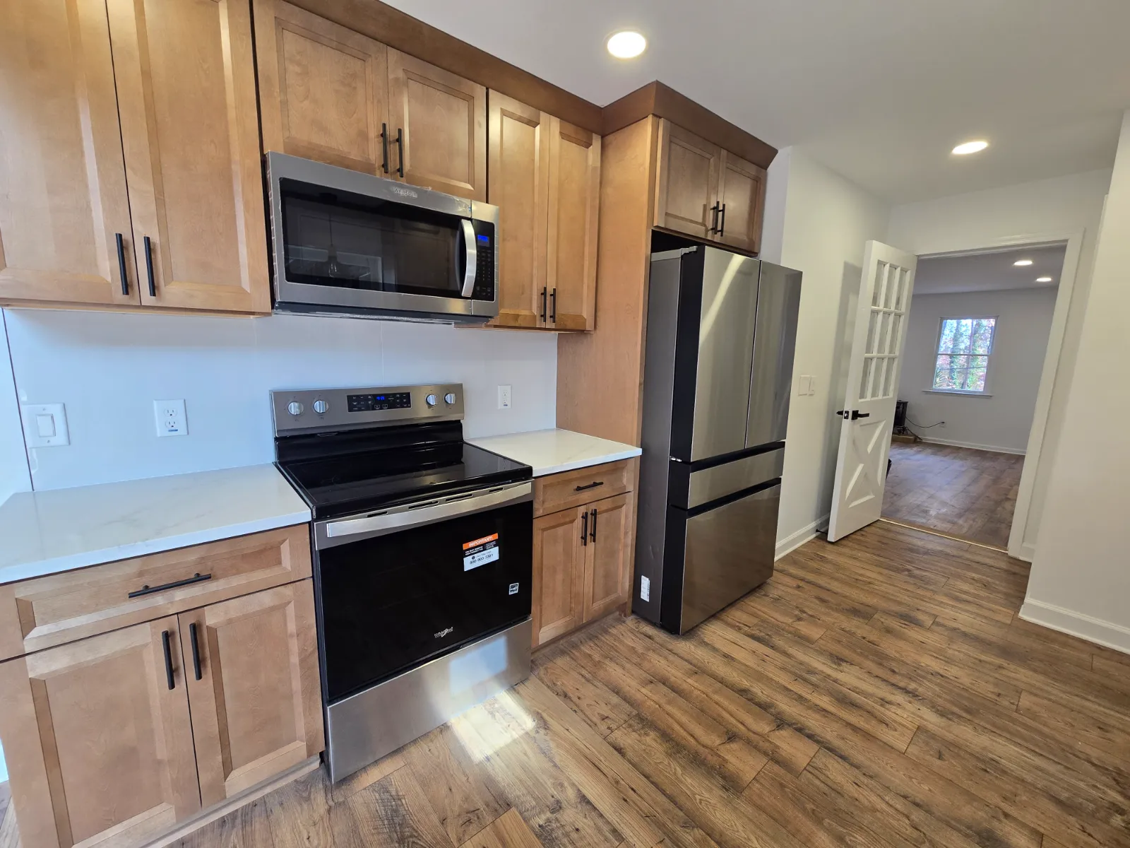 Remodeled kitchen with wood cabinets, stainless appliances and new flooring