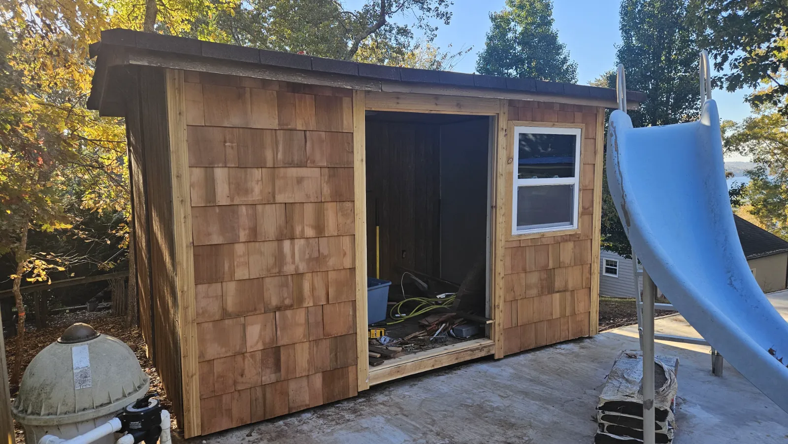 Rebuilt backyard shed with new cedar shingle siding and window